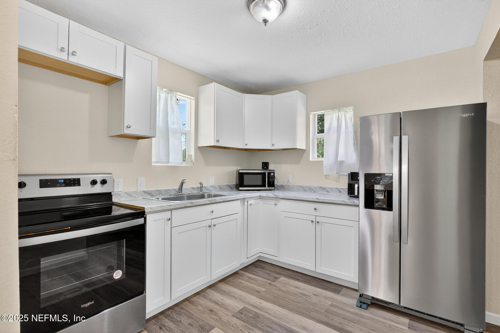 631 Moore Street Baldwin, FL 32234 - Photo 15 of 36 a kitchen with stainless steel appliances granite countertop a stove a refrigerator and a microwave