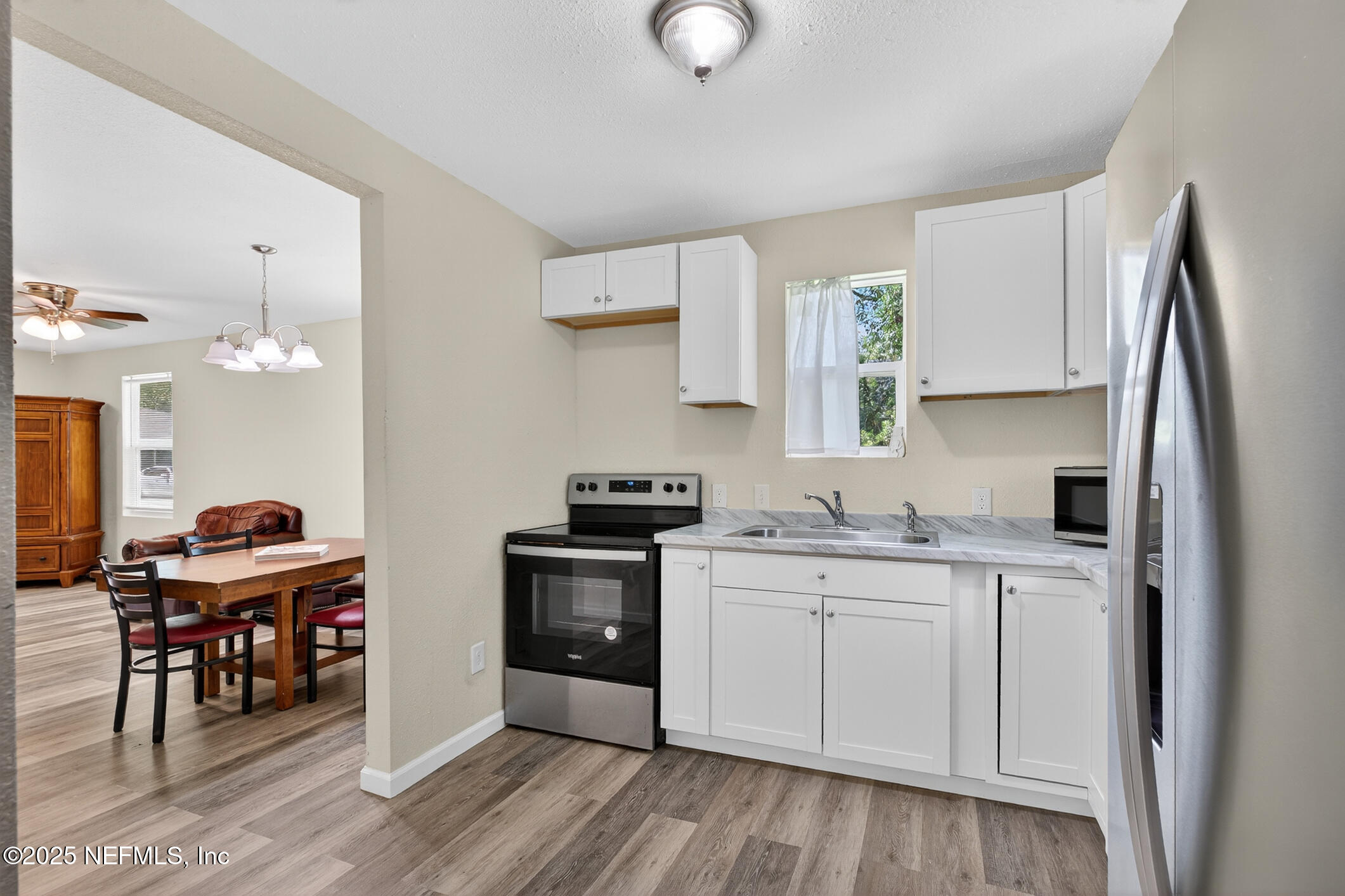 631 Moore Street Baldwin, FL 32234 - Photo 16 of 36 a kitchen with stainless steel appliances granite countertop a sink stove and cabinets