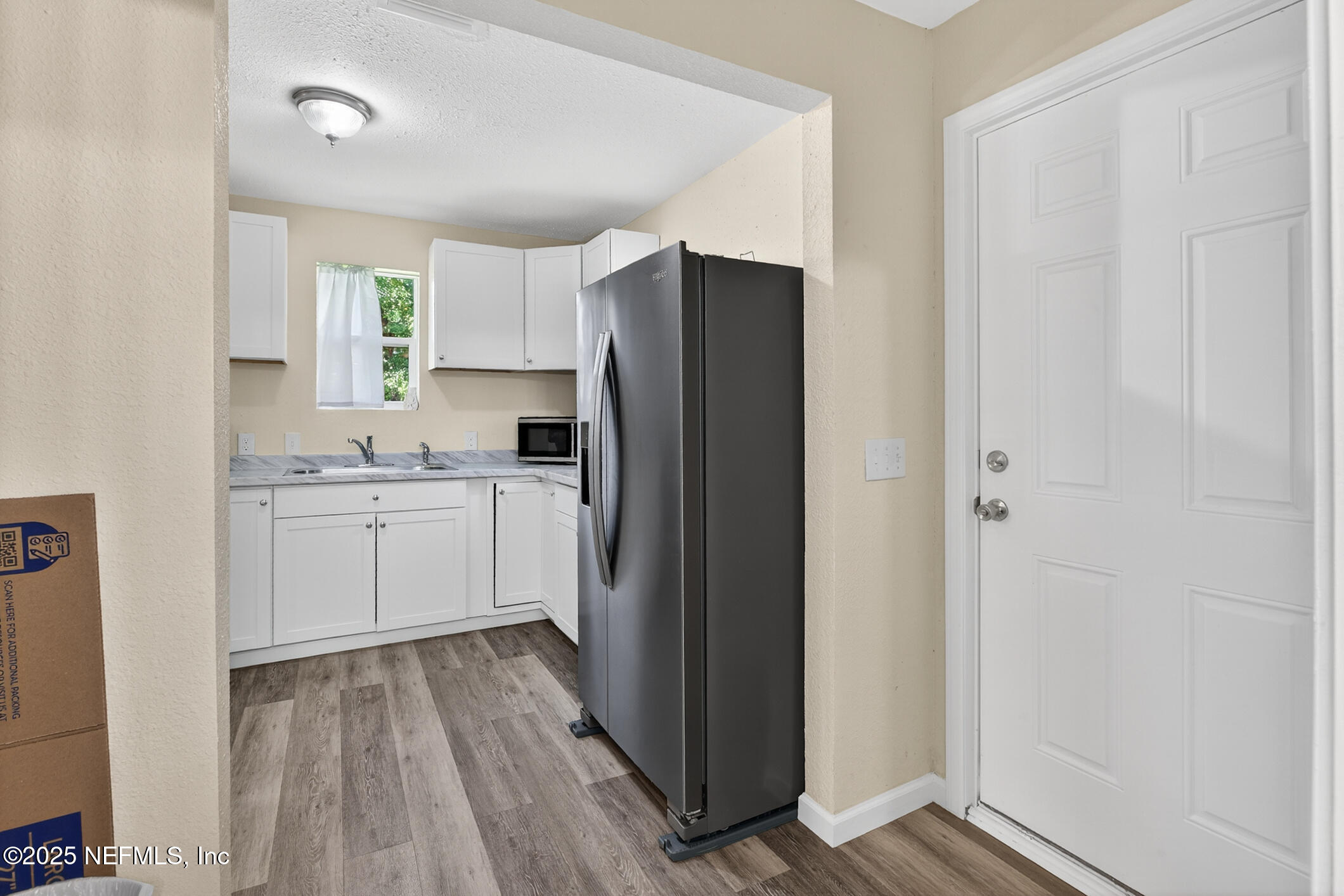 631 Moore Street Baldwin, FL 32234 - Photo 22 of 36 a kitchen with a refrigerator a sink and cabinets