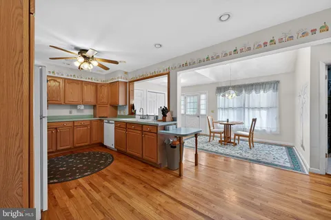 a kitchen with table chairs cabinets and wooden floor