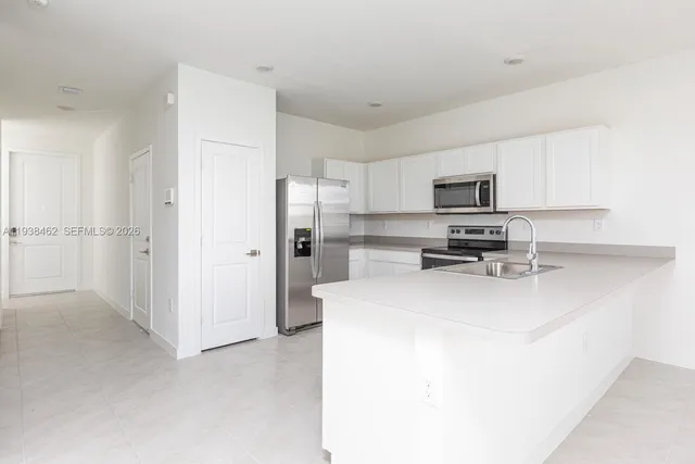 a kitchen with a refrigerator a stove a microwave and cabinets