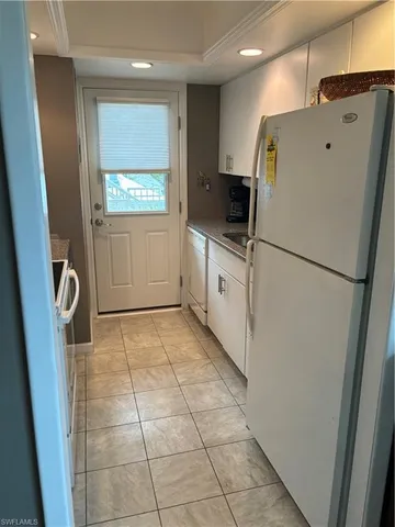 a kitchen with a refrigerator a stove top oven and cabinets