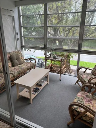 a room with gym equipment wooden floor and a large window
