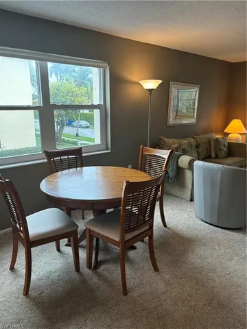 a view of a dining room with furniture and window