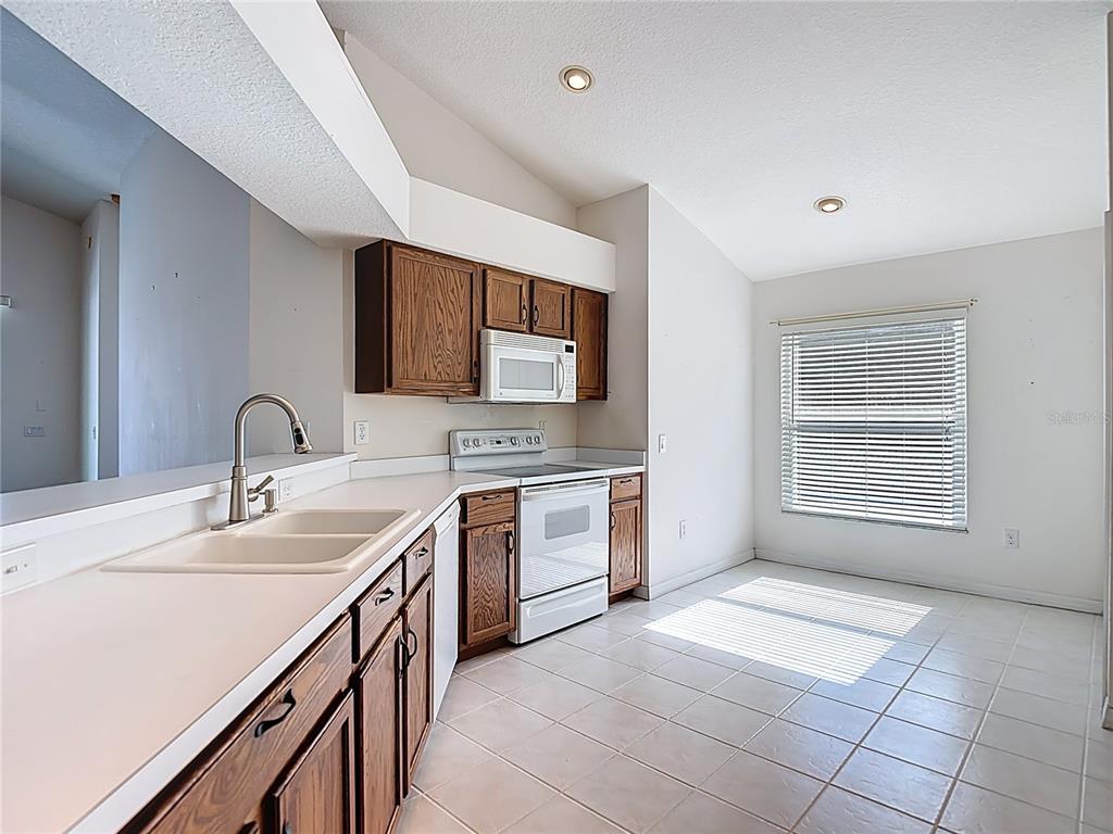 4824 Woodmere Road Land O Lakes, FL 34639 - Photo 18 of 50 a kitchen with a sink stove and cabinets