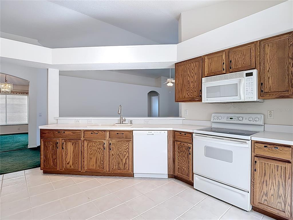 4824 Woodmere Road Land O Lakes, FL 34639 - Photo 19 of 50 a kitchen with stainless steel appliances granite countertop a stove and a sink