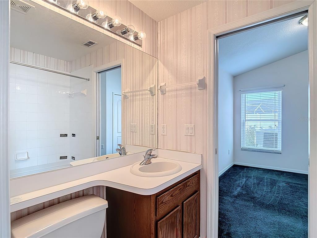4824 Woodmere Road Land O Lakes, FL 34639 - Photo 26 of 50 a bathroom with a sink a mirror and a shower