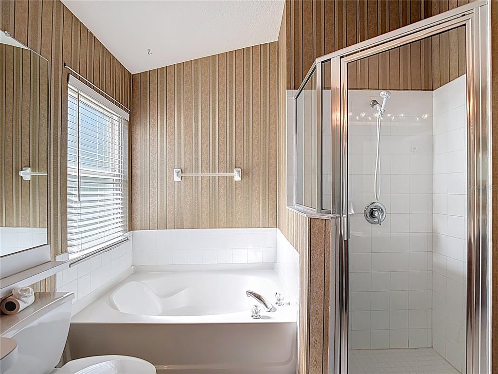 4824 Woodmere Road Land O Lakes, FL 34639 - Photo 34 of 50 a bathroom with a tub shower and a sink