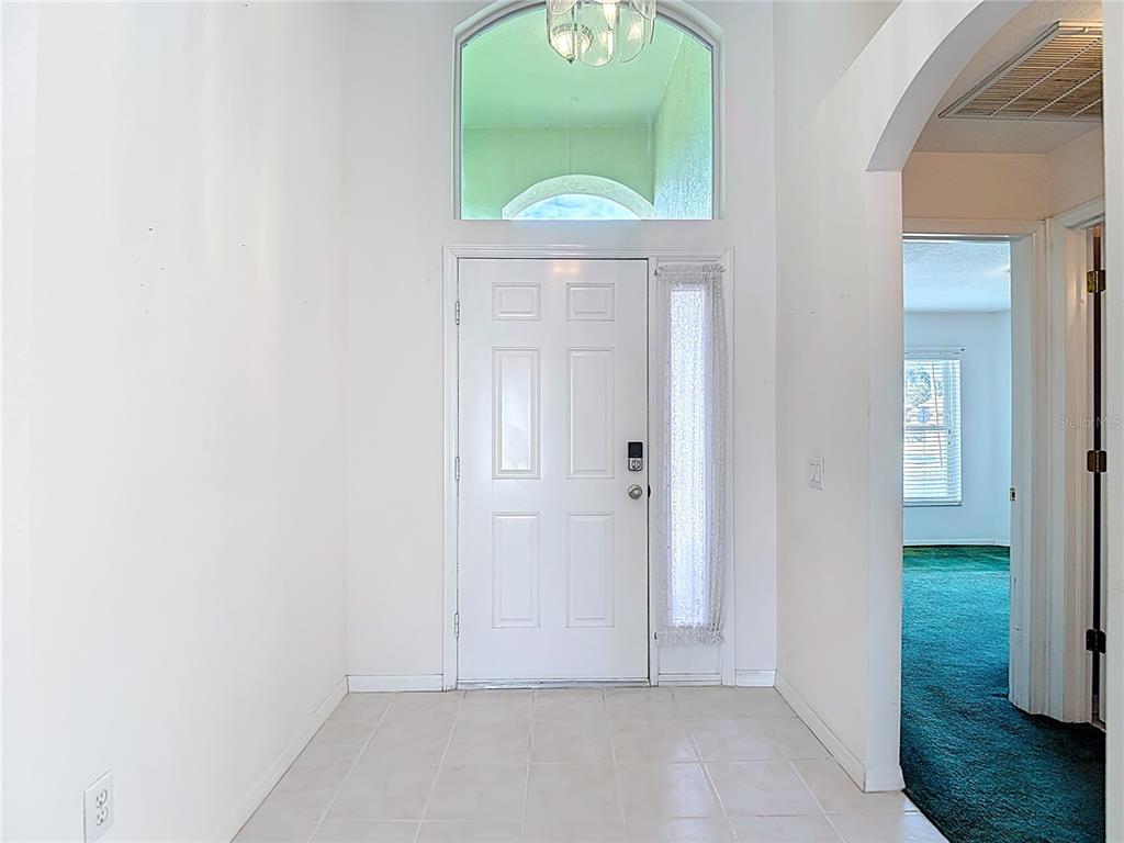 4824 Woodmere Road Land O Lakes, FL 34639 - Photo 10 of 50 an empty room with windows and a mirror