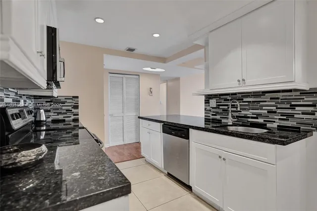 a kitchen with stainless steel appliances granite countertop a refrigerator and a sink