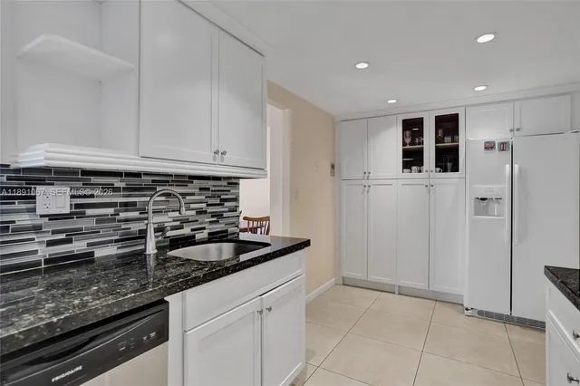 a kitchen with stainless steel appliances granite countertop a refrigerator a stove and a sink