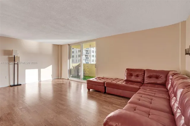 a living room with furniture a window and wooden floor