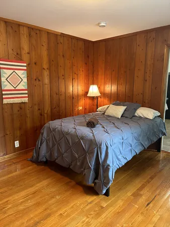 a bedroom with a bed and painting on the wall