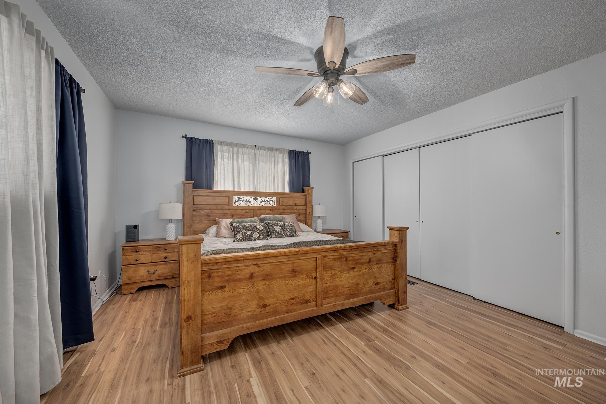 1009 County Road 70 Weiser, ID 83672 - Photo 15 of 48 Bedroom featuring light wood-style floors, a textured ceiling, a ceiling fan, and a closet