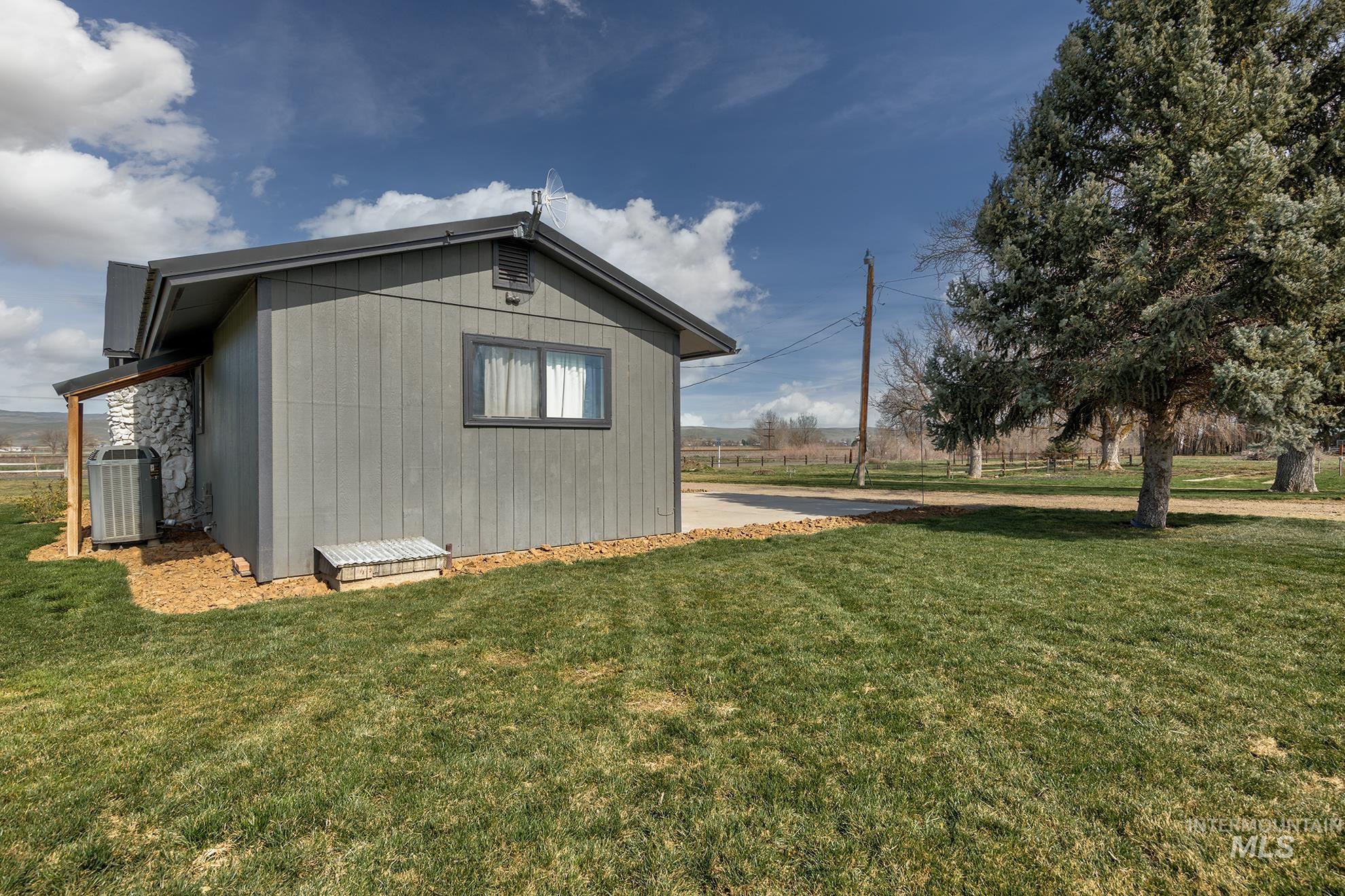 1009 County Road 70 Weiser, ID 83672 - Photo 19 of 48 View of property exterior featuring a central AC unit and a yard