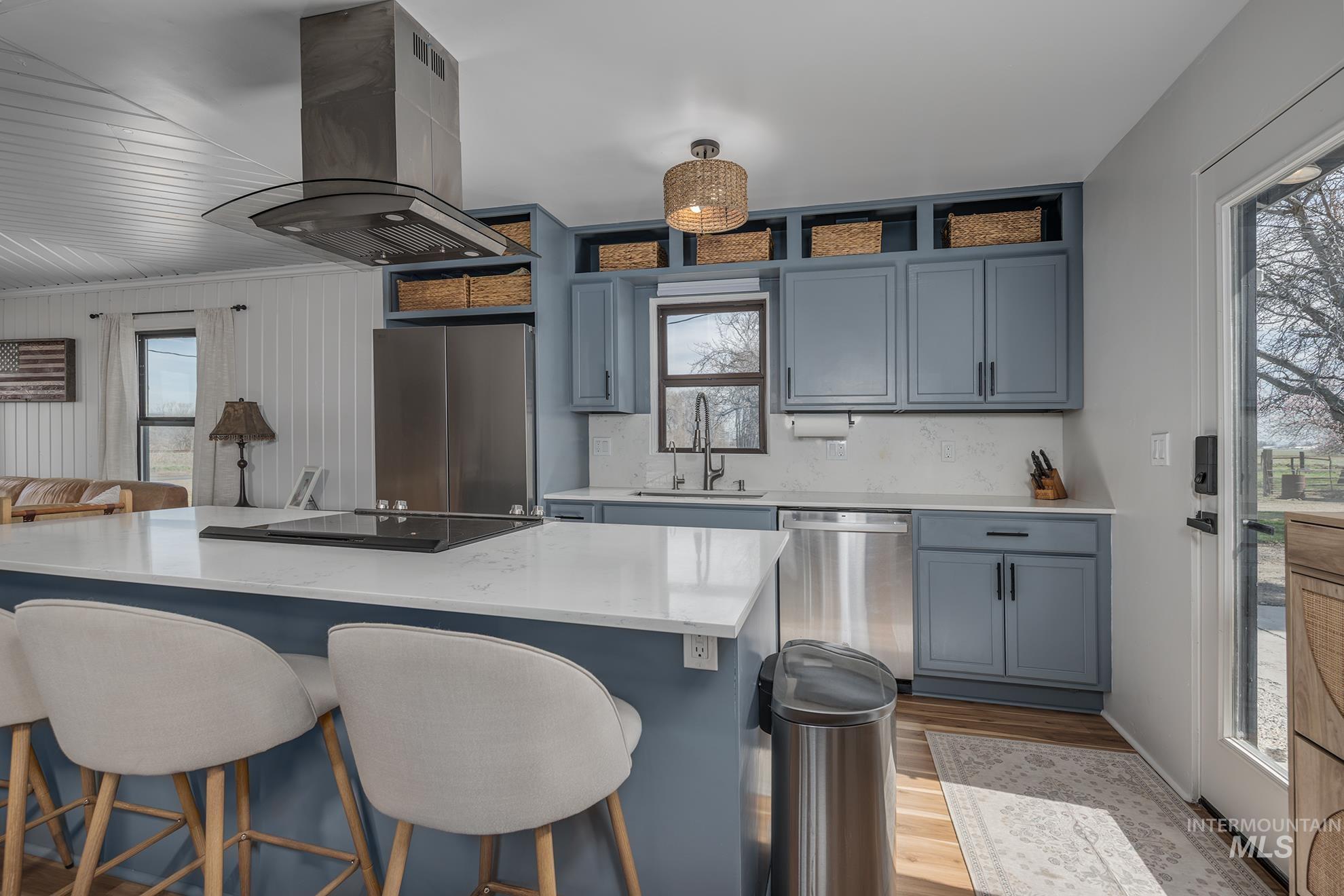 1009 County Road 70 Weiser, ID 83672 - Photo 8 of 48 Kitchen with island exhaust hood, stainless steel appliances, light stone counters, a kitchen island, and light wood finished floors