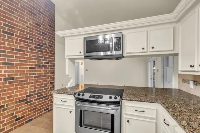 a kitchen with granite countertop a stove and a sink