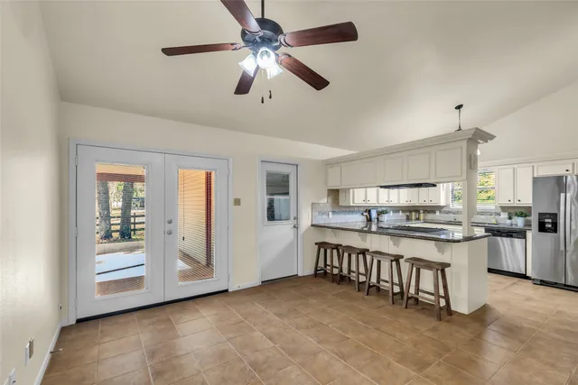 a large kitchen with stainless steel appliances granite countertop a stove and a refrigerator