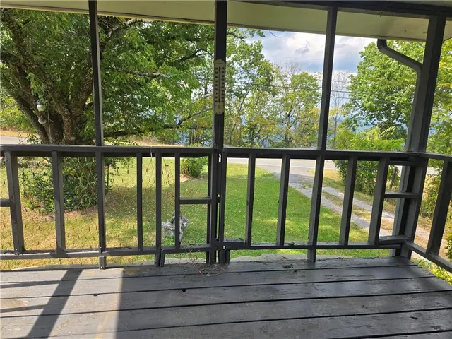 a view of empty room with wooden floor and windows