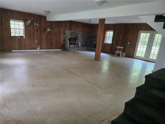 an empty room with windows and fireplace