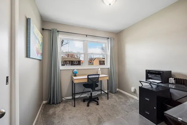 a view of a workspace with furniture and a window