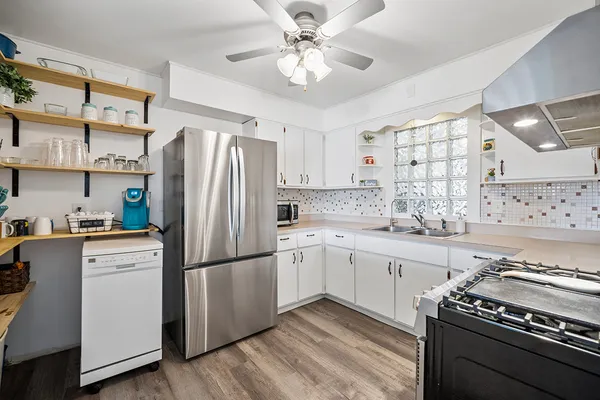 a kitchen with stainless steel appliances a stove a sink and a refrigerator