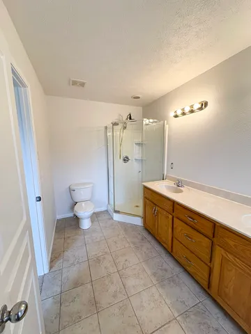 a bathroom with a granite countertop sink toilet and shower