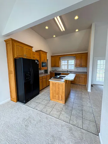 a kitchen with stainless steel appliances granite countertop a refrigerator and a stove