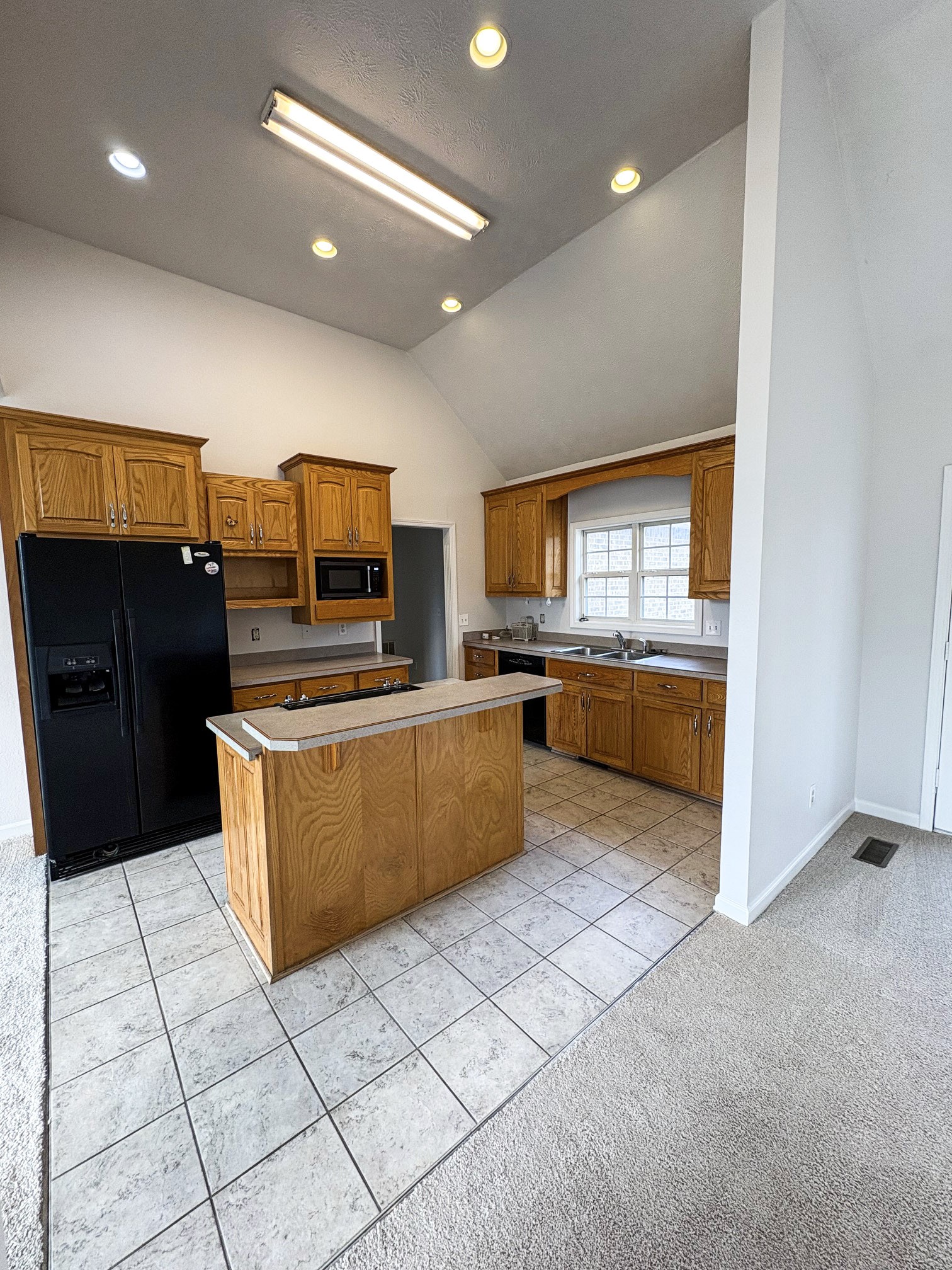1508 Gray Fox Lane Spring Hill, TN 37174 - Photo 10 of 22 a large kitchen with a counter top space a sink a window and stainless steel appliances
