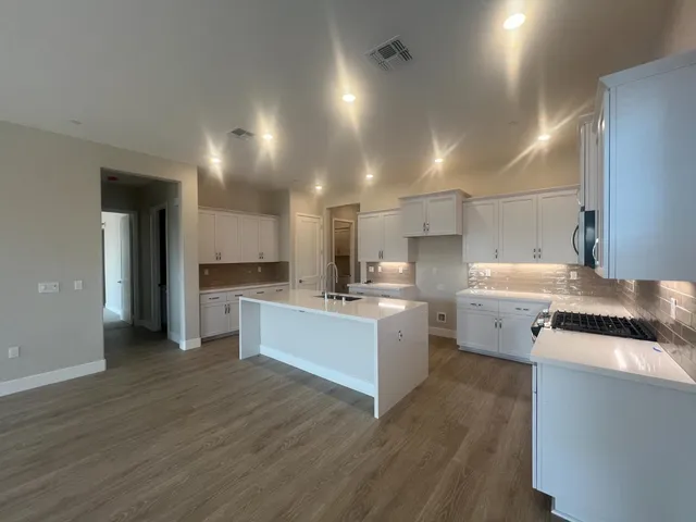 a kitchen with a sink cabinets and wooden floor