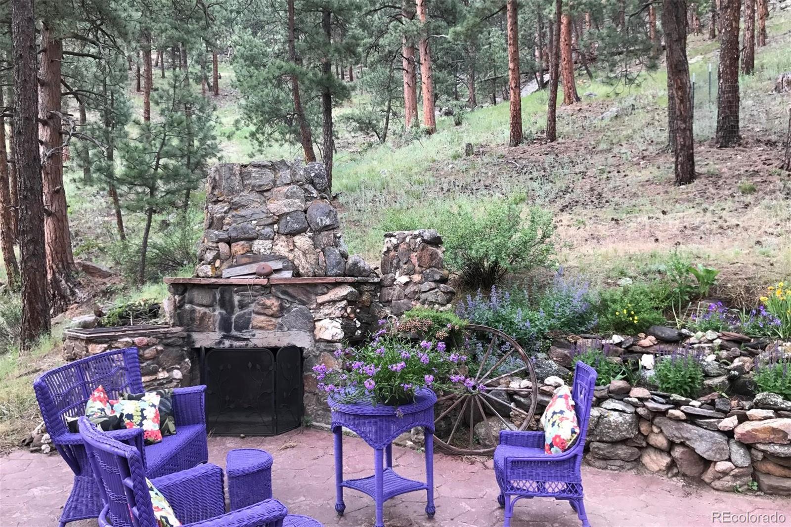 3010 Kerr Gulch Road Evergreen, CO 80439 - Photo 32 of 32 a view of a chairs and table in a backyard