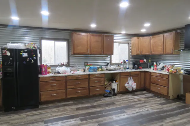 a kitchen with stainless steel appliances granite countertop a refrigerator a stove a sink and a microwave