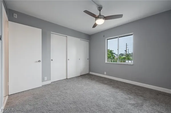 an empty room with a window and a fan