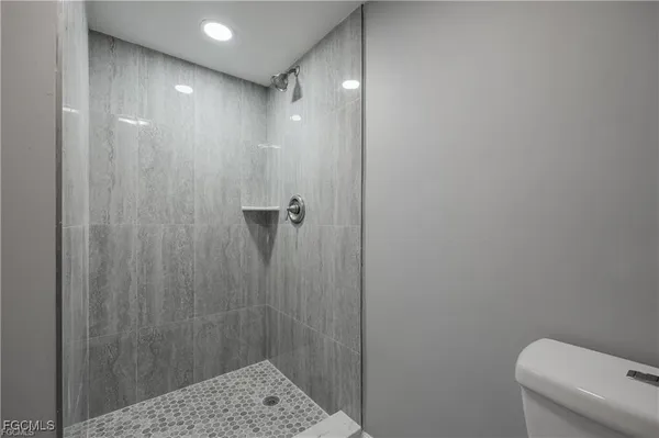 a bathroom with a shower a toilet and sink