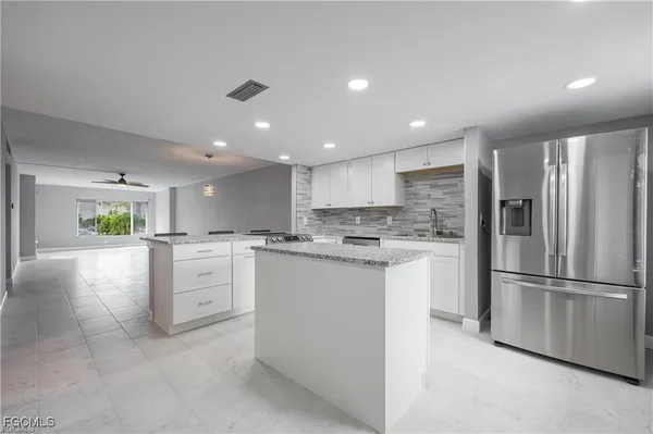 a kitchen with white cabinets and stainless steel appliances
