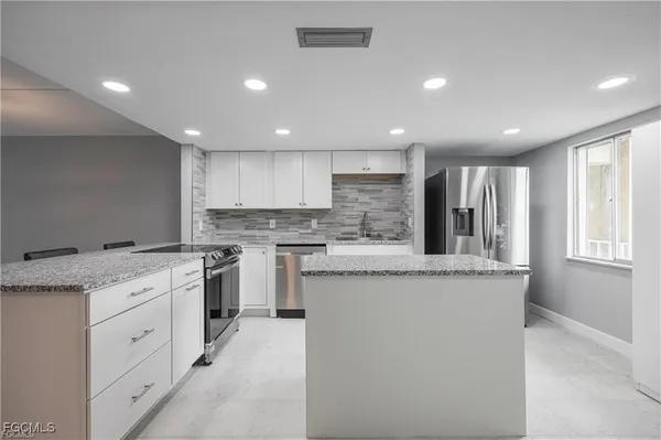 a kitchen with granite countertop cabinets stainless steel appliances and a sink