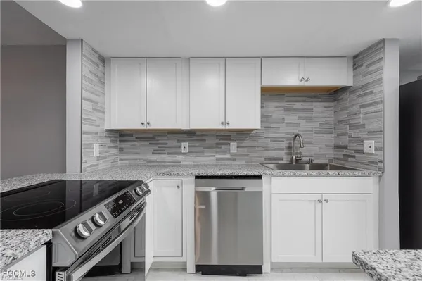 a kitchen with stainless steel appliances granite countertop a sink stove and cabinets