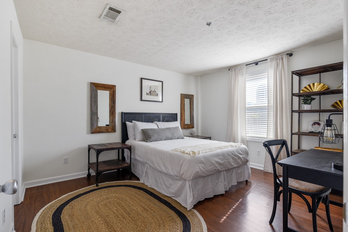 1808 State Street, Unit 307 Nashville, TN 37203 - Photo 15 of 27 a bedroom with a bed and a table in it
