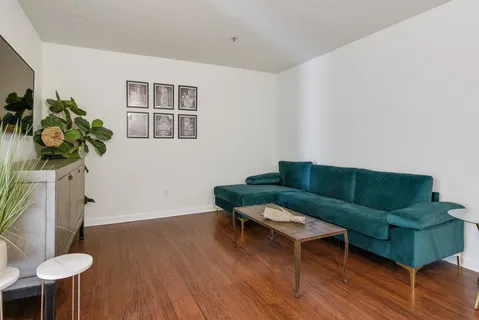a living room with furniture and a wooden floor