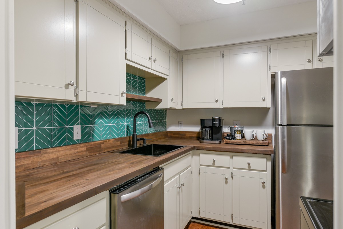 1808 State Street, Unit 307 Nashville, TN 37203 - Photo 9 of 27 a kitchen with a sink a refrigerator and cabinets