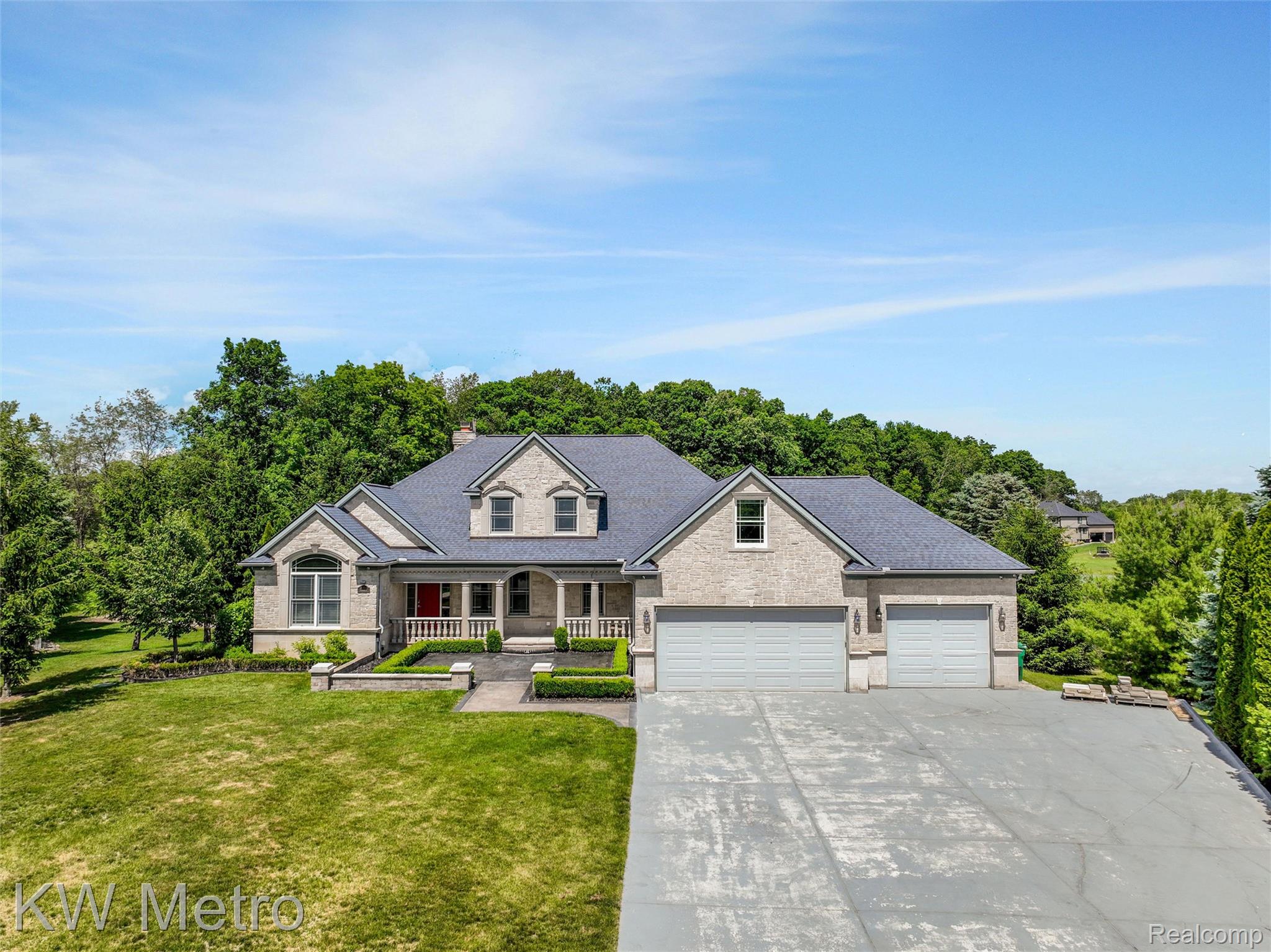 65884 Windrose Court Ray, MI 48096 - Photo 2 of 82 Stone facade residence with a multi-car driveway and an expansive front lawn