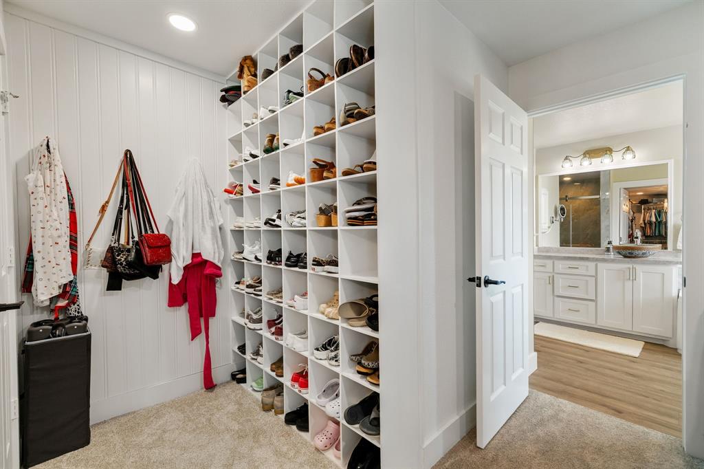 12240 Wellington Road Ponder, TX 76259 - Photo 26 of 40 Custom built-in shoe storage with individual cubbies, soft carpet flooring, white paneled walls, and recessed lighting