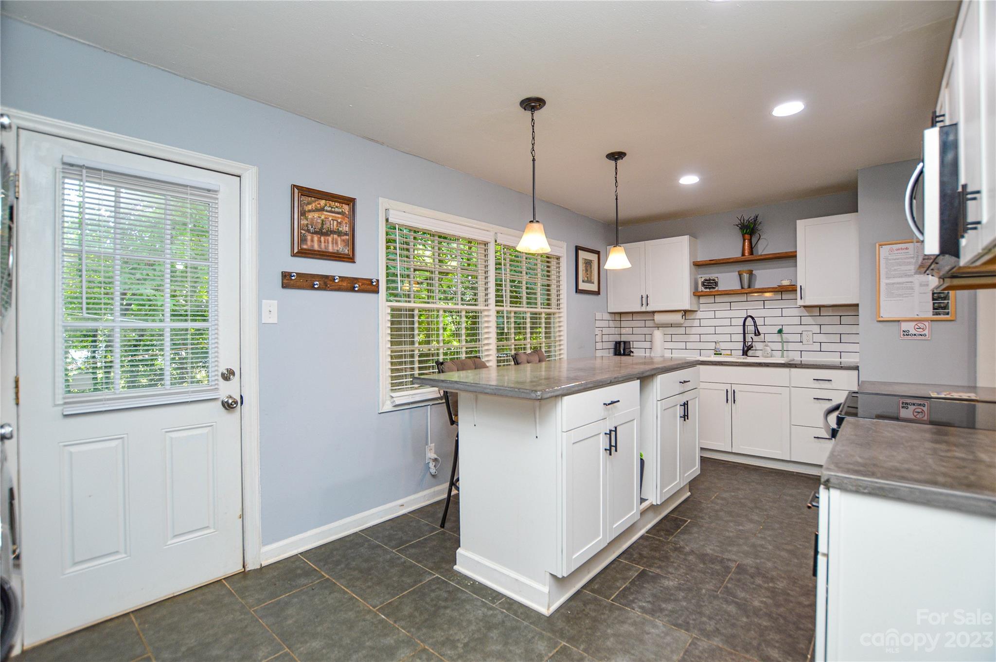 931 Tilden Road Charlotte, NC 28214 - Photo 13 of 33 a kitchen with granite countertop white cabinets and white appliances