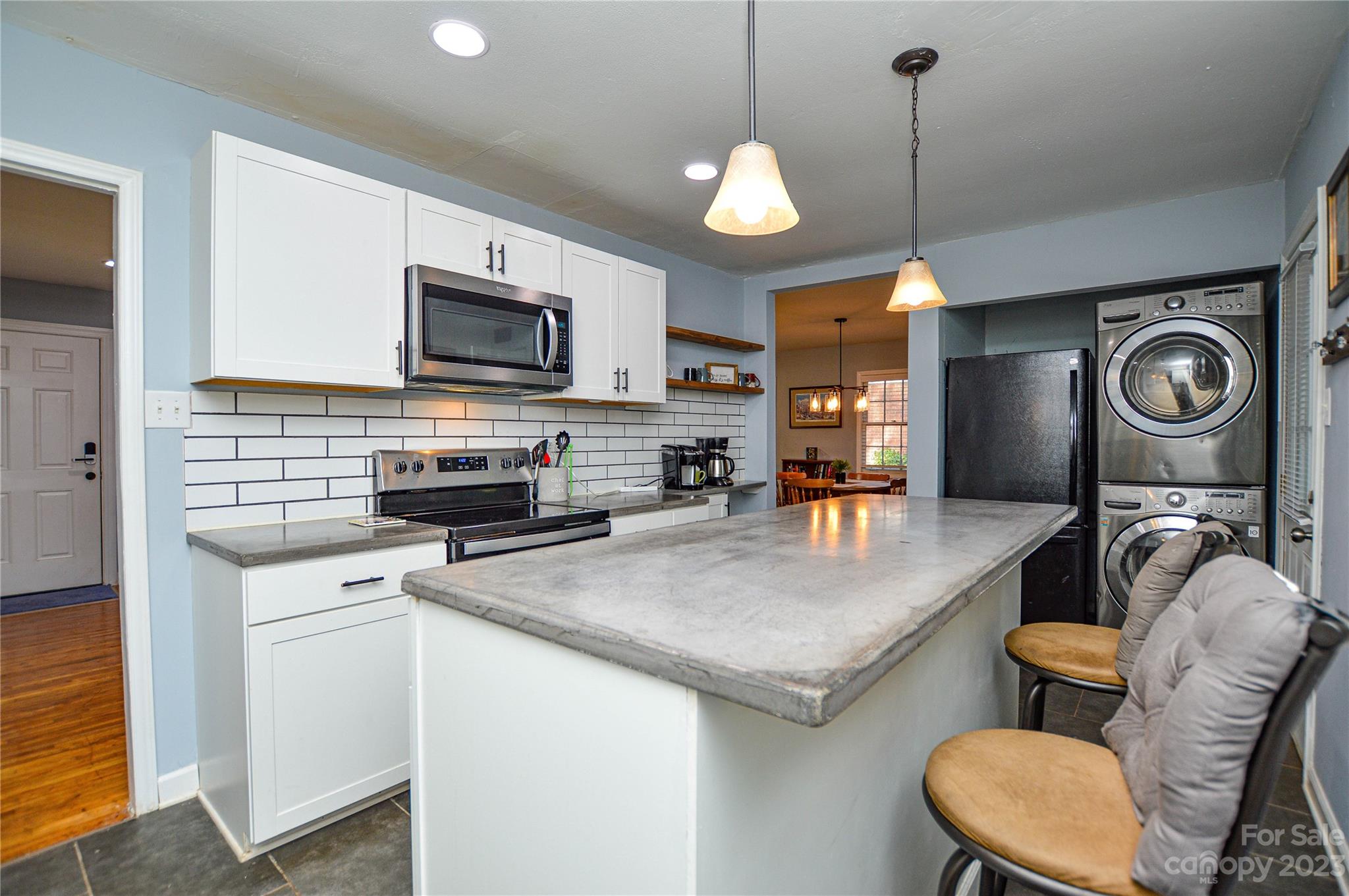 931 Tilden Road Charlotte, NC 28214 - Photo 16 of 33 a kitchen with stainless steel appliances granite countertop a stove top oven a sink dishwasher a dining table and chairs with wooden floor