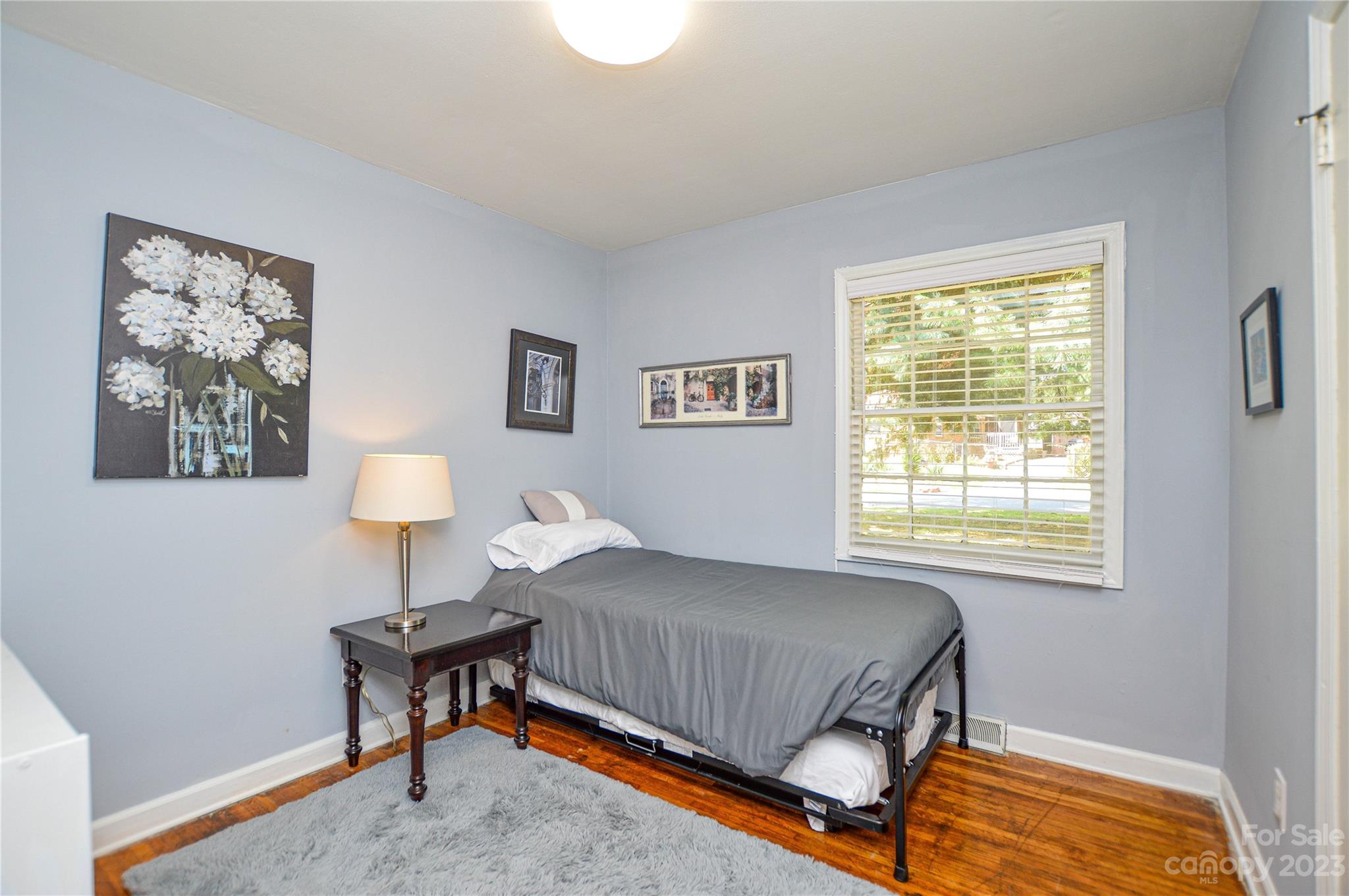 931 Tilden Road Charlotte, NC 28214 - Photo 19 of 33 a bedroom with a bed and a lamp next to a window