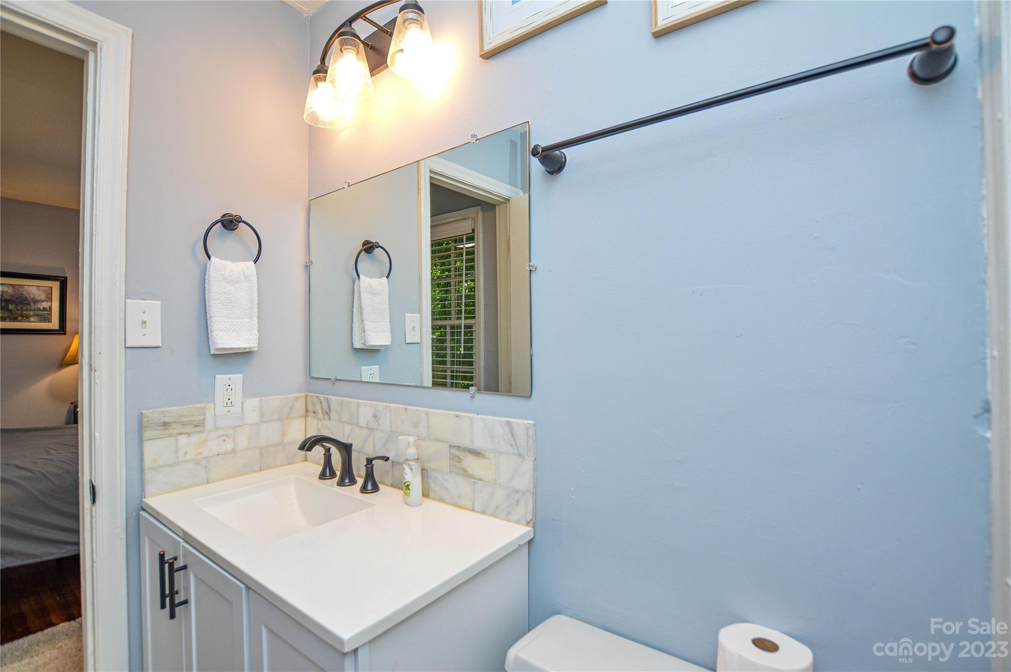 931 Tilden Road Charlotte, NC 28214 - Photo 30 of 33 a bathroom with a sink vanity mirror and toilet