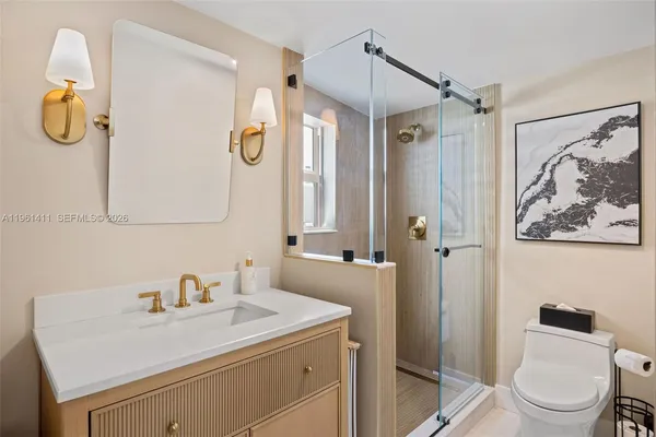 a bathroom with a sink vanity mirror and toilet
