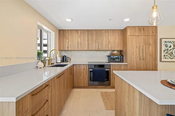 a kitchen with a sink a stove a refrigerator cabinets and a window