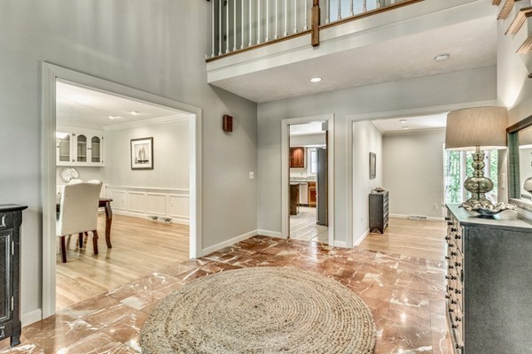 42 Phillips Road Sudbury, MA 01776 - Photo 4 of 28 a view of a hallway to a livingroom with wooden floor and furniture