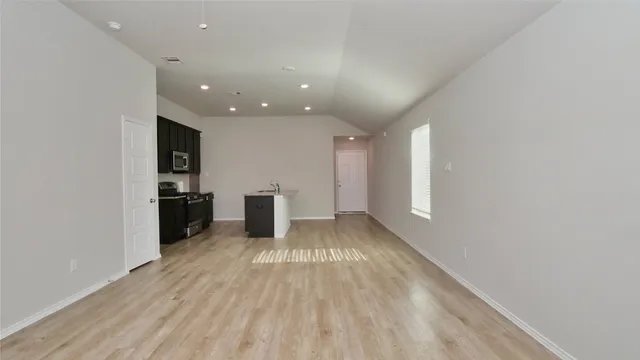 a view of kitchen with refrigerator sink and cabinets